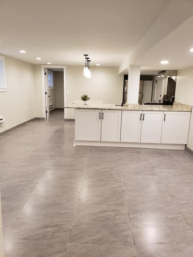 kitchen with pendant lighting, light stone countertops, and white cabinets