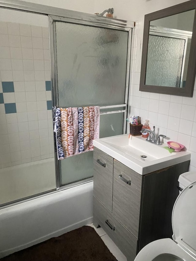 full bathroom with enclosed tub / shower combo, tile walls, vanity, tasteful backsplash, and toilet