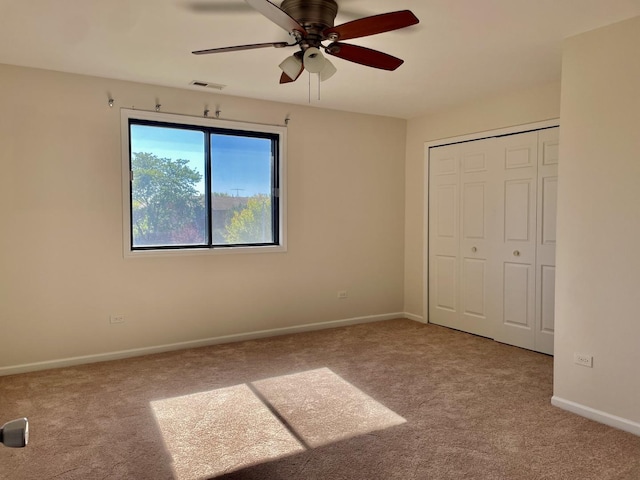 unfurnished bedroom with ceiling fan, light colored carpet, and a closet