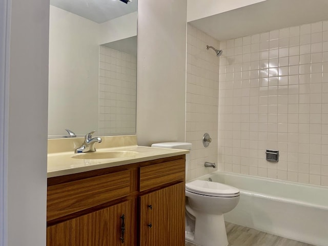 full bathroom featuring hardwood / wood-style flooring, toilet, vanity, and tiled shower / bath