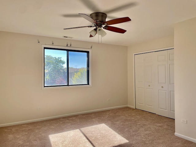 unfurnished bedroom with ceiling fan, a closet, and light colored carpet