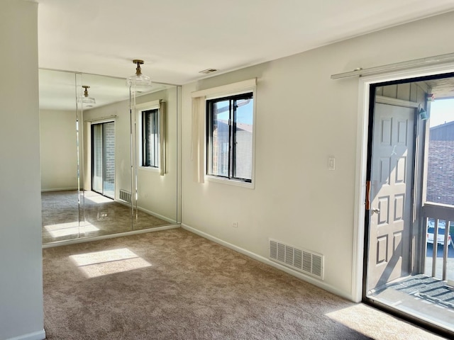 carpeted empty room with a healthy amount of sunlight