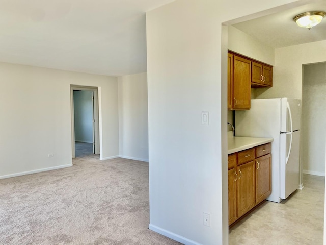 kitchen with white fridge and light carpet