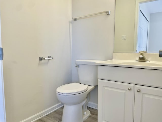 bathroom featuring toilet, hardwood / wood-style floors, and vanity