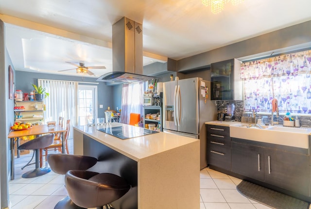 kitchen with black electric stovetop, a kitchen island, sink, island exhaust hood, and light tile patterned floors