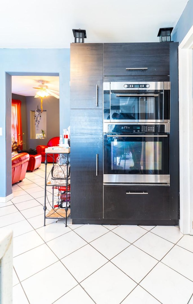 kitchen featuring double oven and light tile patterned flooring