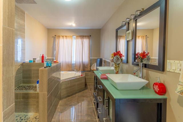 bathroom with a relaxing tiled tub, tile patterned floors, and vanity