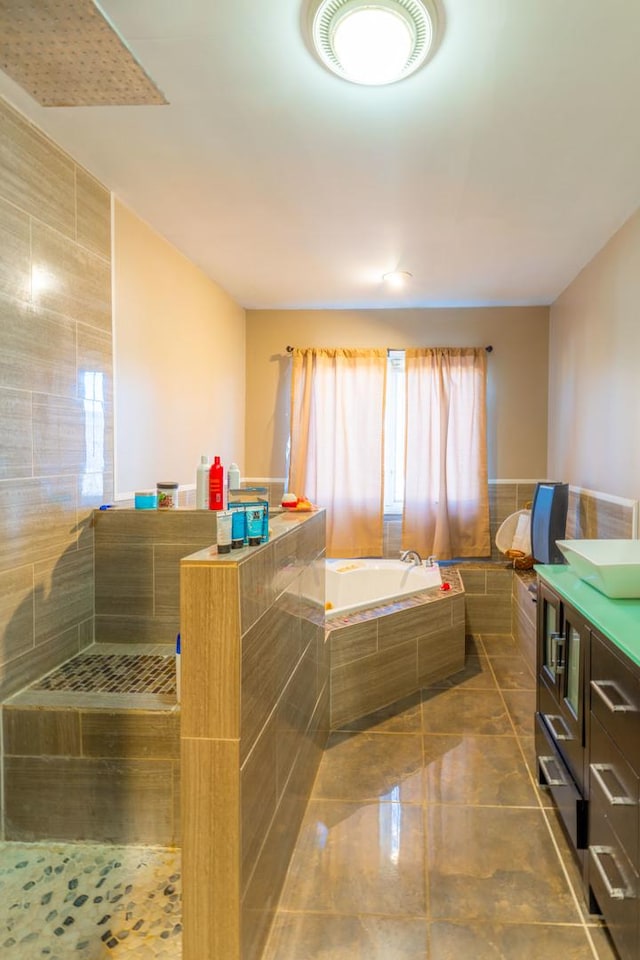 bathroom with vanity and a relaxing tiled tub