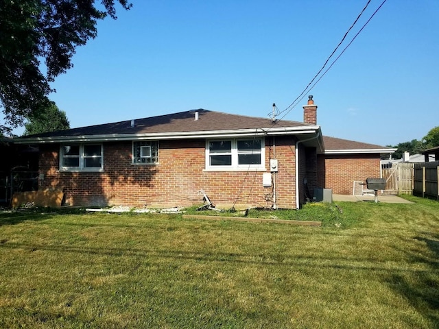 rear view of property with a lawn