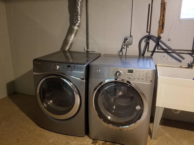 clothes washing area featuring sink and independent washer and dryer