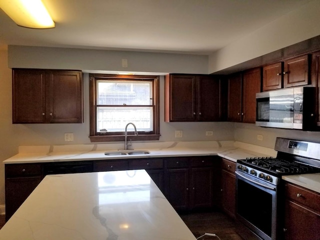 kitchen featuring stainless steel appliances, dark brown cabinets, and sink