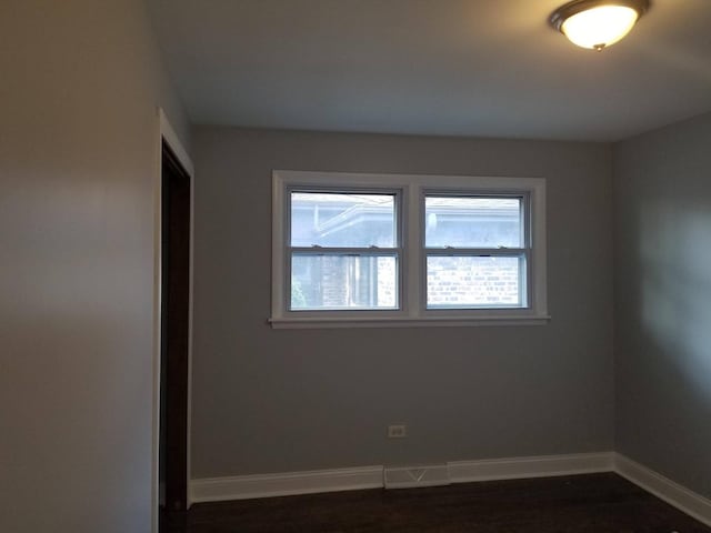 unfurnished room with dark hardwood / wood-style flooring