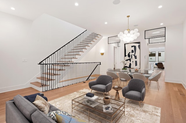 living room featuring a chandelier and light wood-type flooring