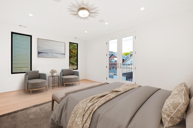 bedroom featuring access to exterior, french doors, crown molding, and wood-type flooring