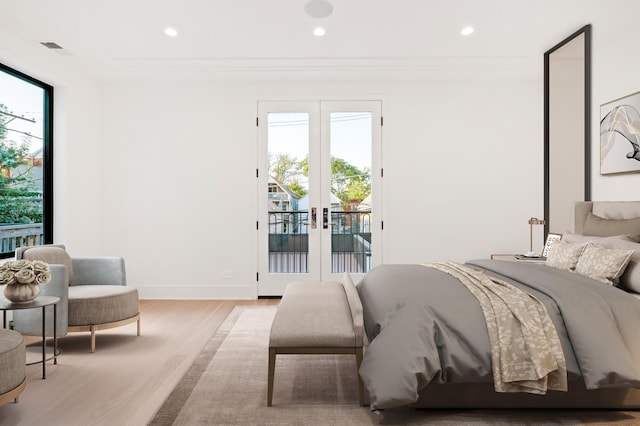 bedroom featuring light wood-type flooring, crown molding, french doors, and access to outside