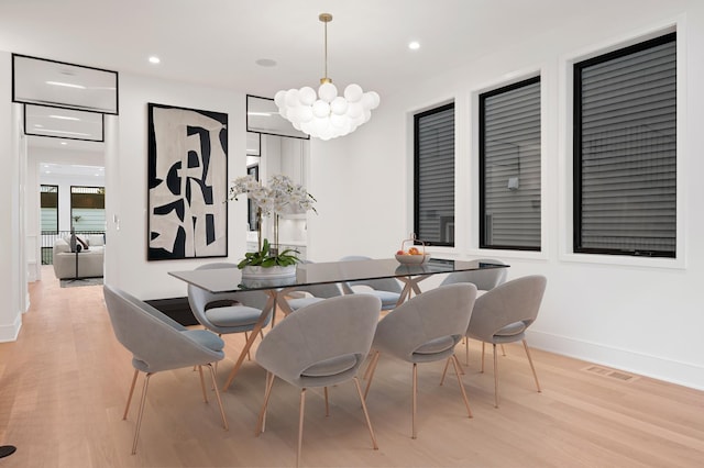 dining area with a notable chandelier and light wood-type flooring