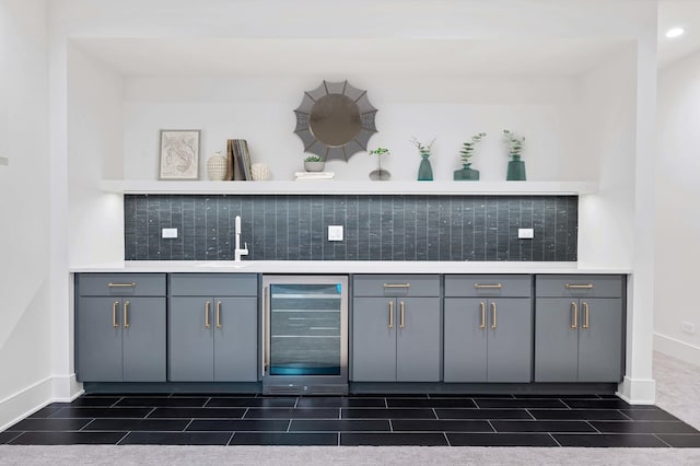 bar with tasteful backsplash, sink, beverage cooler, and gray cabinets