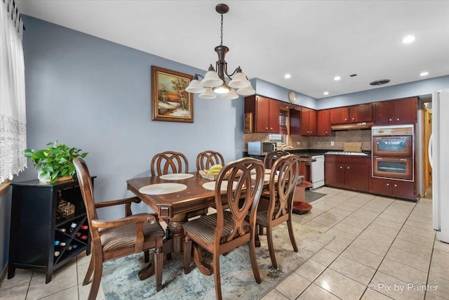 tiled dining area featuring an inviting chandelier