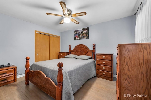 bedroom featuring light hardwood / wood-style flooring, ceiling fan, and a closet