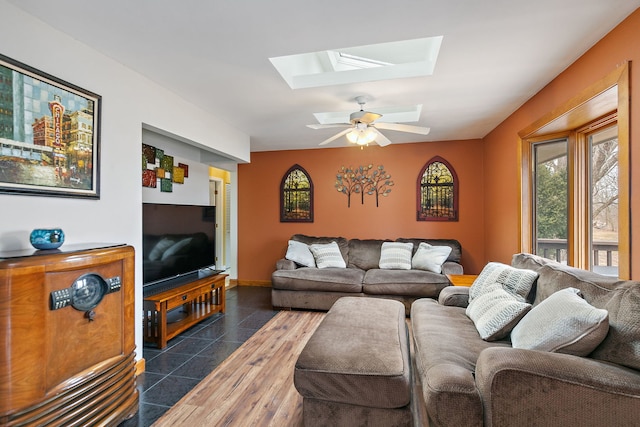 living room featuring a skylight, dark hardwood / wood-style floors, and ceiling fan