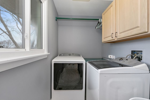 clothes washing area featuring separate washer and dryer and cabinets