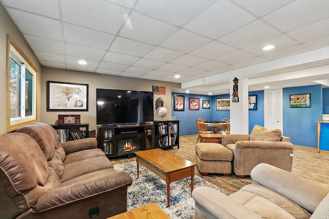 living room with a drop ceiling and hardwood / wood-style floors