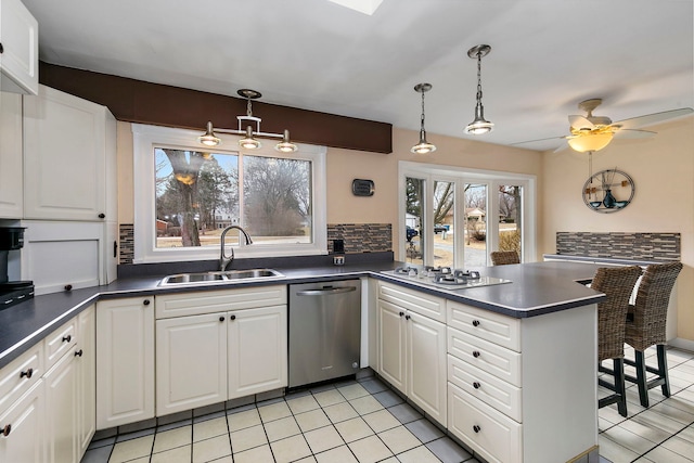 kitchen featuring white gas stovetop, decorative light fixtures, sink, white cabinets, and stainless steel dishwasher