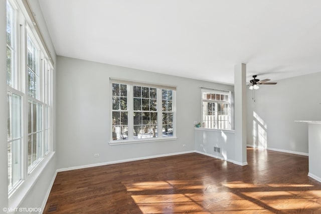 unfurnished room featuring dark hardwood / wood-style flooring, ceiling fan, and a healthy amount of sunlight