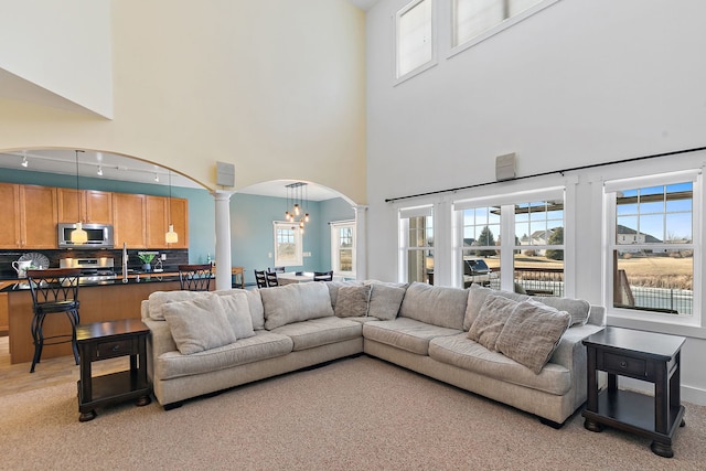 living room featuring decorative columns and a high ceiling