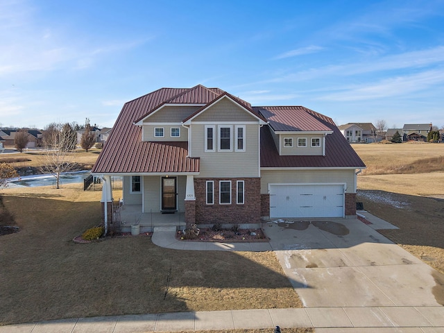 view of front of property with a garage, covered porch, and a front lawn