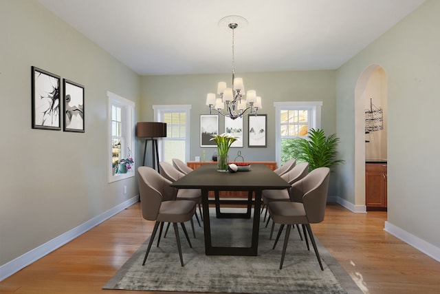 dining area with an inviting chandelier and light hardwood / wood-style flooring