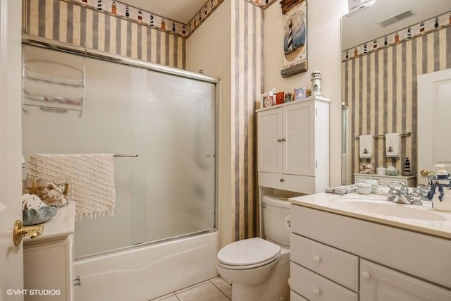 full bathroom featuring vanity, tile patterned flooring, shower / bath combination with glass door, and toilet