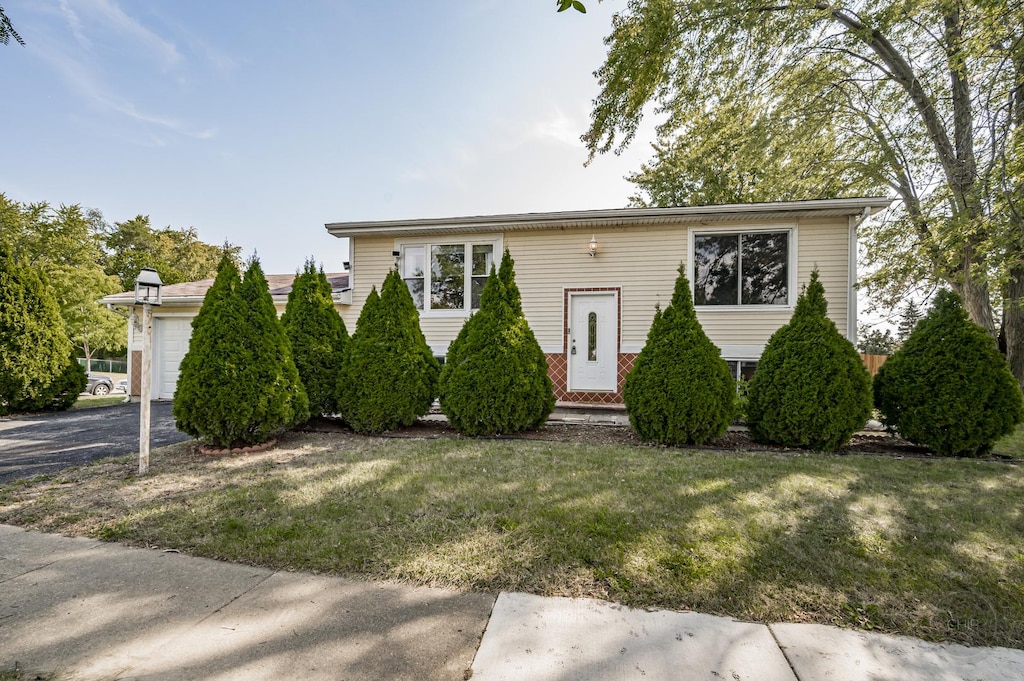 view of front of home with a front lawn and a garage