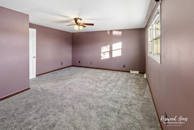 carpeted empty room featuring ceiling fan and a textured ceiling