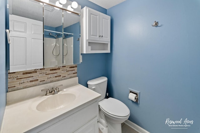 bathroom featuring a textured ceiling, vanity, decorative backsplash, toilet, and walk in shower