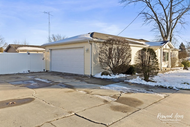 view of snowy exterior featuring a garage