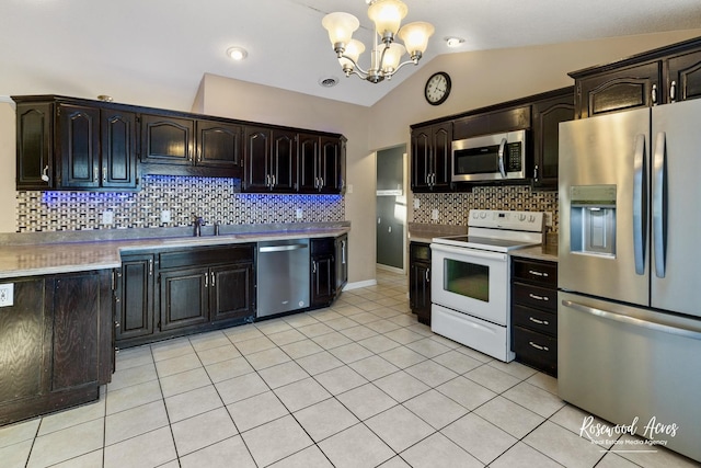 kitchen with vaulted ceiling, backsplash, sink, an inviting chandelier, and stainless steel appliances