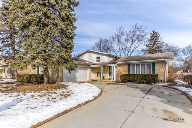 view of front of house with a garage, concrete driveway, and brick siding