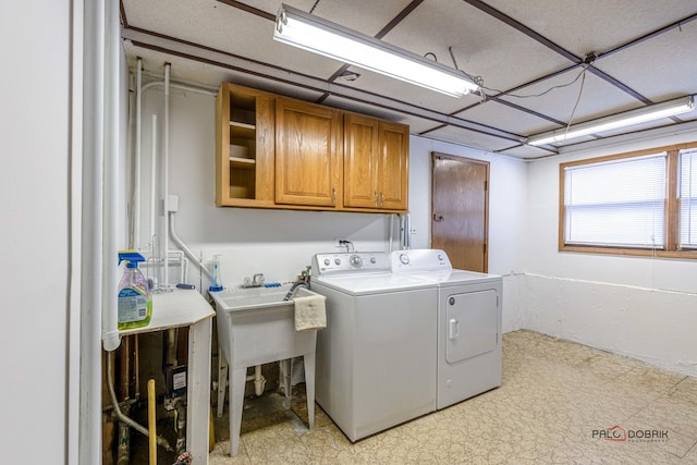 washroom with light floors, washer and clothes dryer, a sink, and cabinet space