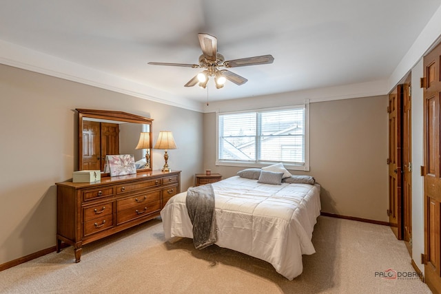 bedroom with light colored carpet, ceiling fan, and baseboards