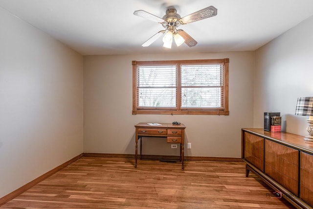 home office featuring a ceiling fan, light wood-type flooring, and baseboards