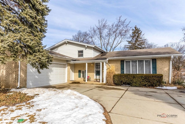 view of front of property with driveway, brick siding, and an attached garage