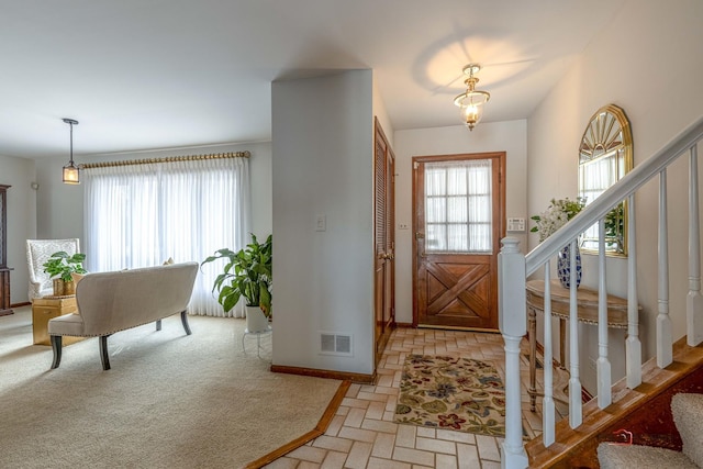 entryway with stairs, visible vents, and a healthy amount of sunlight