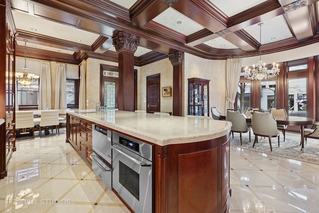 915 N Dearborn St, Chicago, IL 60610 - kitchen featuring pendant lighting, a kitchen island with sink, light countertops, coffered ceiling, and a notable chandelier