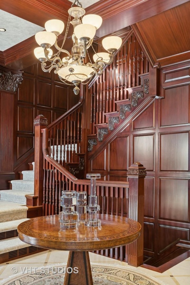 915 N Dearborn St, Chicago, IL 60610 - staircase featuring a chandelier, a decorative wall, wood walls, and crown molding
