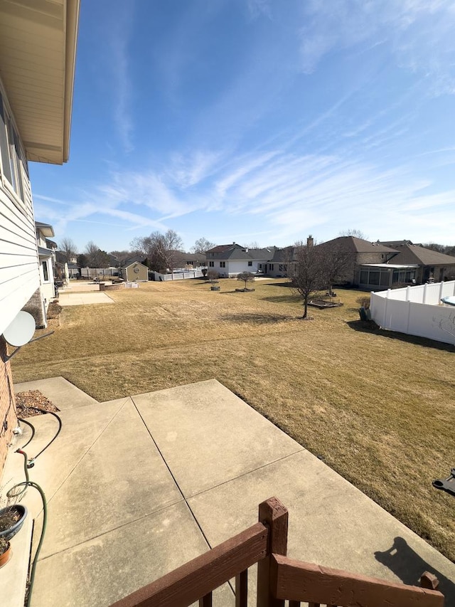 view of yard featuring a residential view, a patio area, and fence