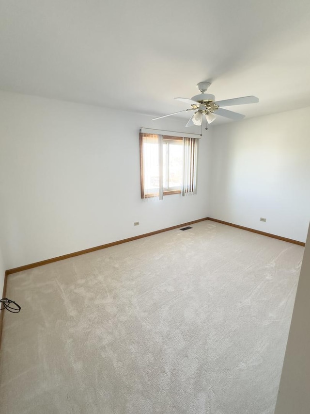 unfurnished room featuring light colored carpet, ceiling fan, visible vents, and baseboards