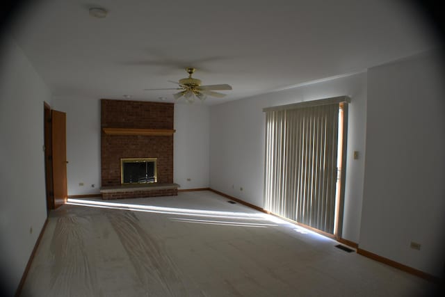 unfurnished living room featuring a fireplace, light carpet, and ceiling fan