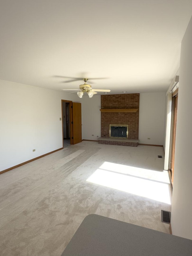 unfurnished living room with carpet floors, baseboards, a fireplace, and visible vents