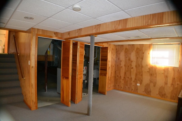 basement featuring carpet and wooden walls